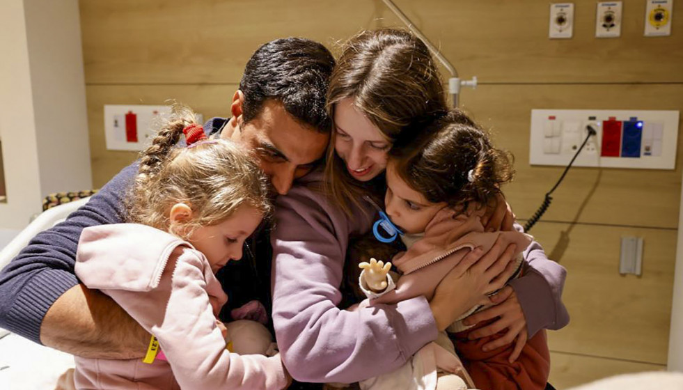 Aviv Asher, de dos años, su hermana Raz de 4 y su madre Doron se reúnen con el padre en Israel, rehenes