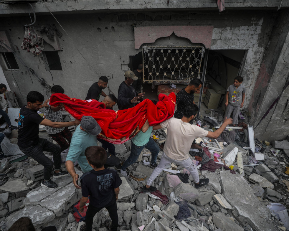 -FOTODELDIA- Al Nusairat (---), 27/04/2024.- Palestinos recuperan los restos de una mujer entre los escombros de una casa destruida tras un ataque aéreo israelí en el campo de refugiados de Al Nusai