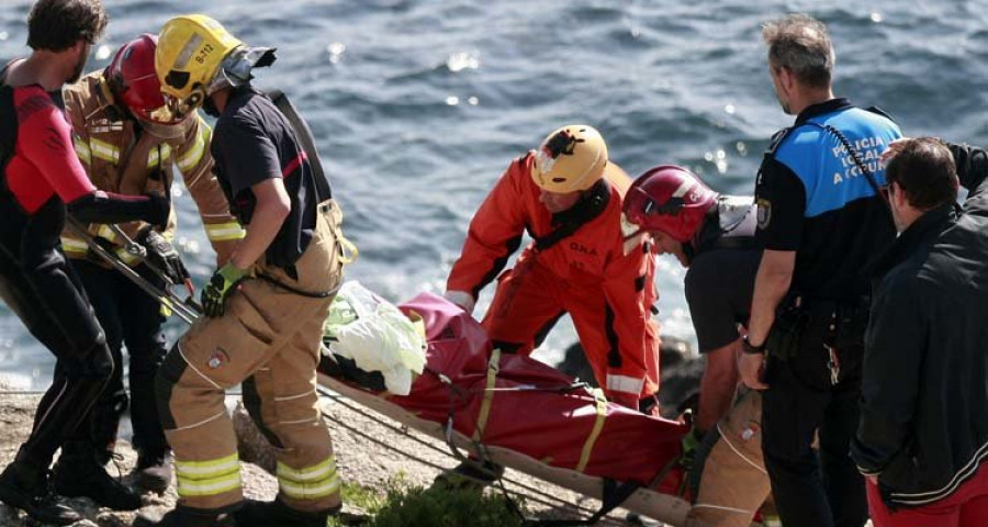 Los bomberos recuperan un cadáver en las rocas al pie 
de la Casa de los Peces