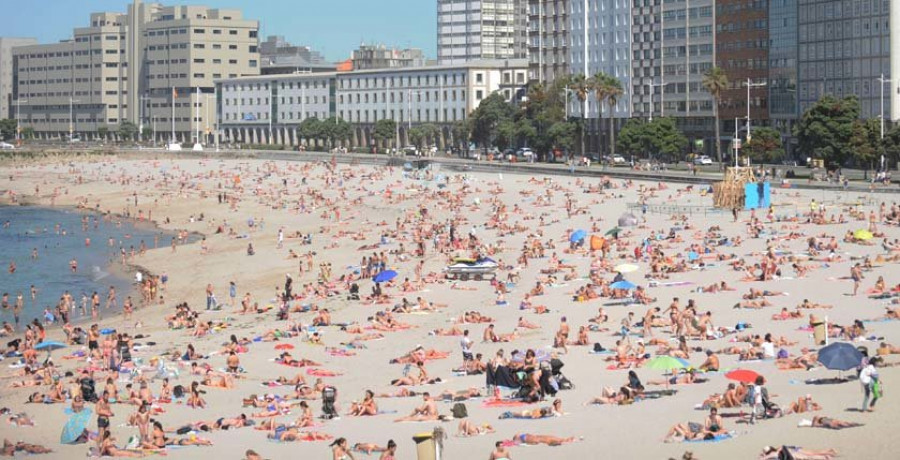 La subida de las temperaturas llena las playas coruñesas 
en pleno montaje de la falla