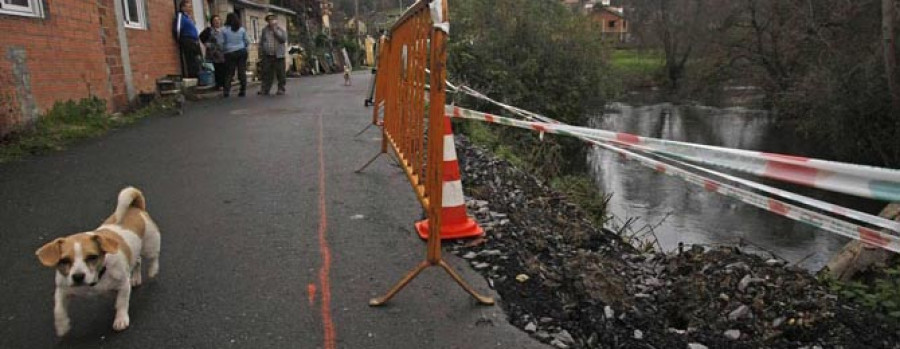 Precintado un tramo de la carretera paralela al río Mero tras hundirse parte del asfalto