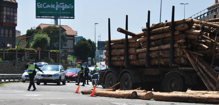 Un trailer esparce una docena de troncos por la glorieta de A Pasaxe a consecuencia  de una colisión