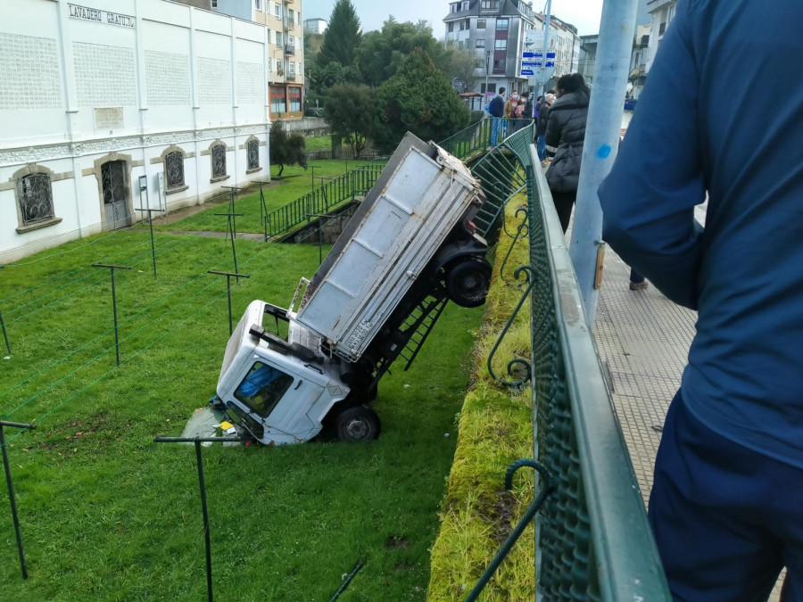 Un conductor sale ileso tras perder el control de un camión, saltar una valla y caer sobre el Lavadero de As Cascas