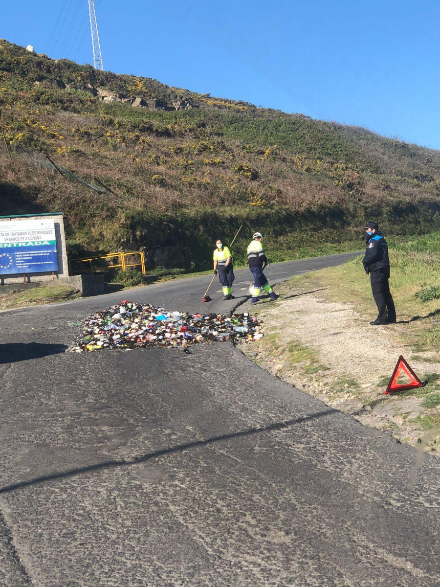 Un camión de la basura  pierde su carga de vidrio en el acceso a la planta de Nostián