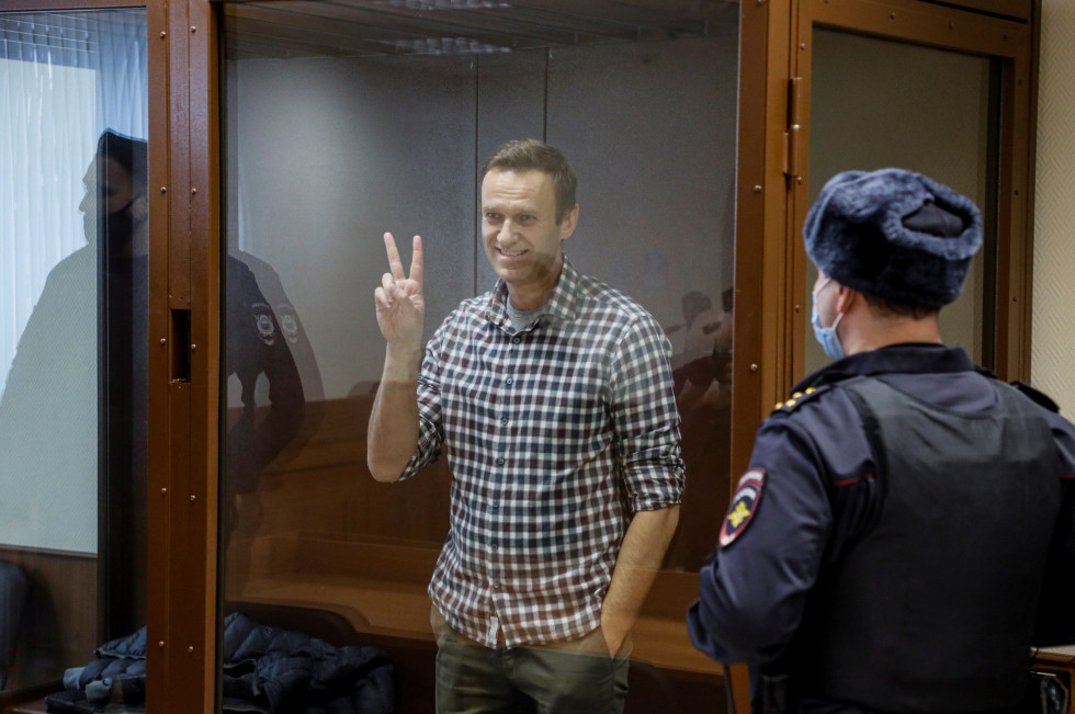 El líder opositor ruso Alexéi Navalni hace el signo de la victoria desde una celda de cristal durante una nueva sesión de su batalla en los tribunales