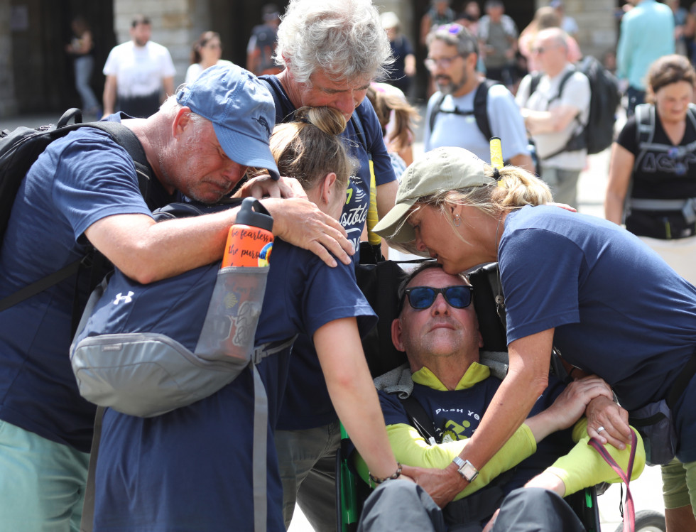 Un grupo de peregrinos de EEUU se abraza al llegar al Obradoiro