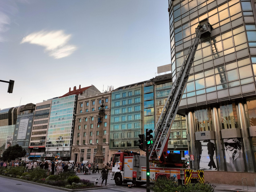 Los bomberos retiran una ventana del edificio de R