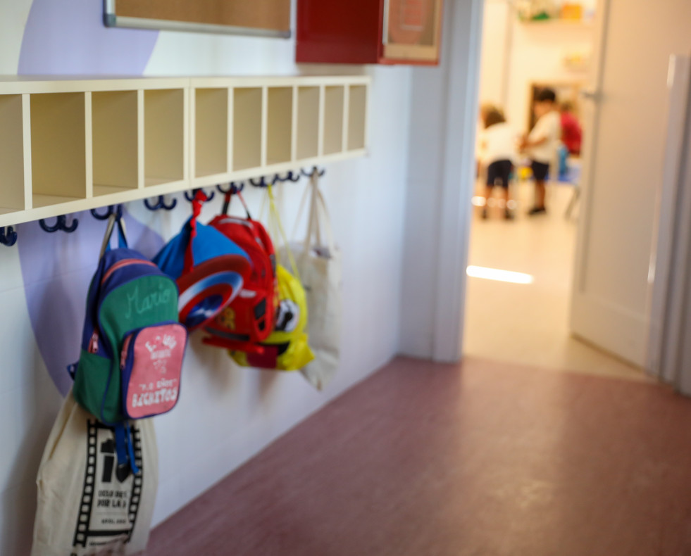 Varias mochilas en una percha de un aula de 0 a 3 años  EP