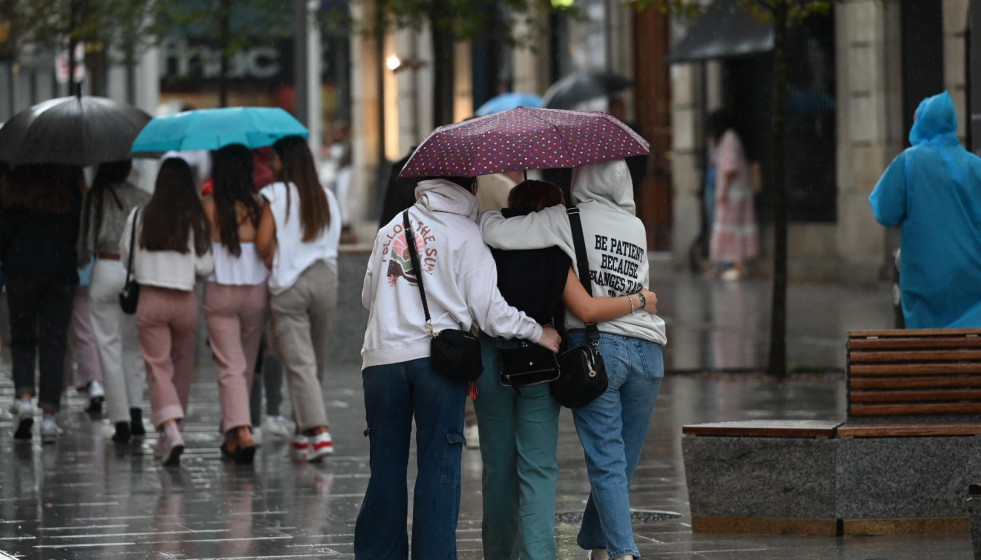 Varias jóvenes se refugian de la lluvia en A Coruña @Pedro Puig
