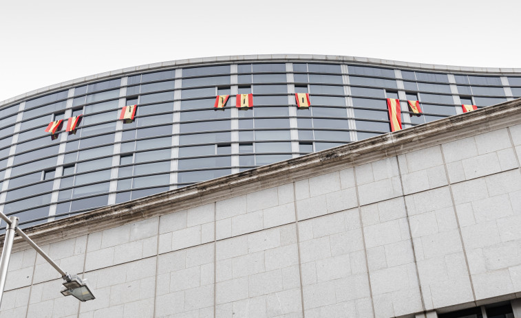 Vox cuelga banderas de España con crespones y el escudo recortado en ventanas del Congreso