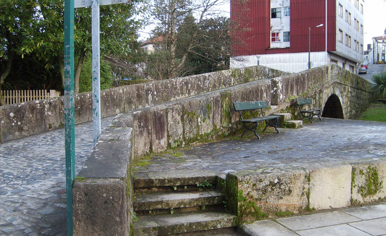 Un camión cargado de coches históricos queda atrapado en un puente antiguo de Santiago