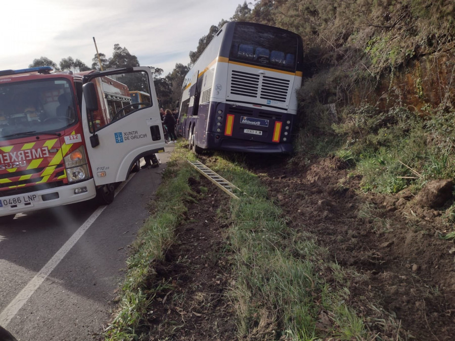Los pasajeros de un autobús salen por la bodega de carga tras un accidente en Lousame