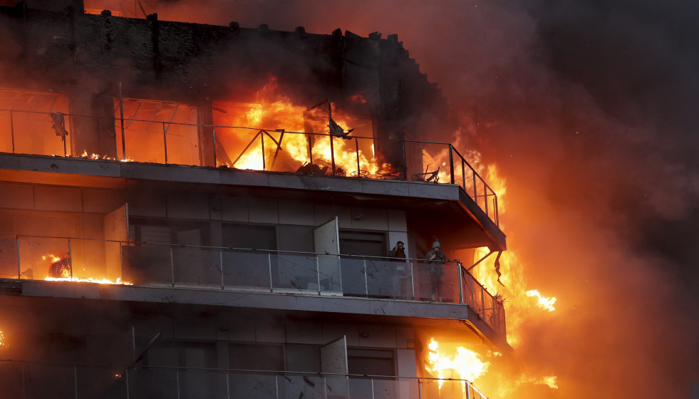 Los bomberos tratan de controlar con ayuda de la Unidad Militar de Emergencias (UME) un devastador incendio iniciado en un edificio de viviendas de catorce alturas en Valencia, que se ha propagado por
