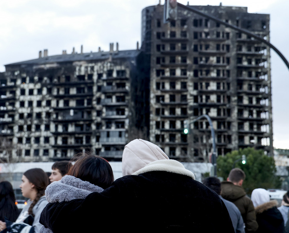 Una pareja observa abrazados el edificio incendiado en el barrio de Campanar de València