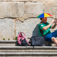 Un hombre se protege del calor con un sombrero sombrila