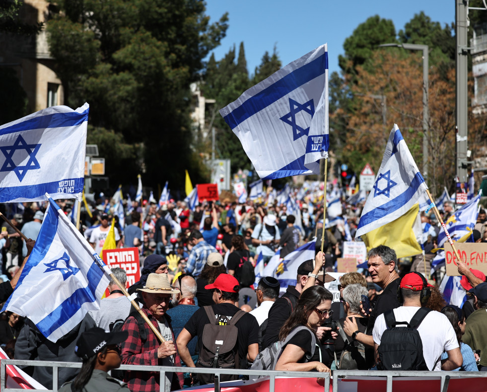 Jerusalem (-), 19/03/2025.- Demontrators wave flags as they take part in a march to protest the resumption of fighting in Gaza and against Israeli Prime Minister Netanyahu's announced plans to dismiss
