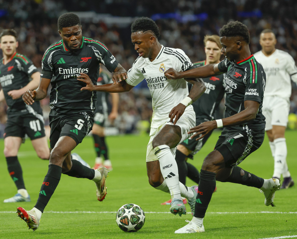 El delantero brasileño del Real Madrid Vinicius Junior (c) rodeado de varios rivales del Arsenal