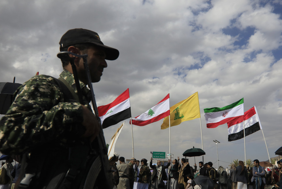 SANA'A (Yemen), 17/03/2025.- A Houthi soldier stands guard as Houthi supporters wave the flags of the Iran-backed axis of resistance (R-L) Yemen, Iran, Hezbollah, Lebanon and Iraq, during a protest in