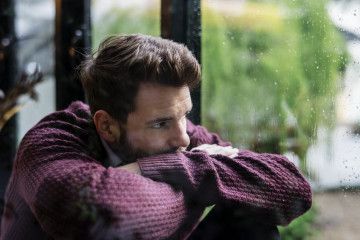 Thoughtful man looking out window