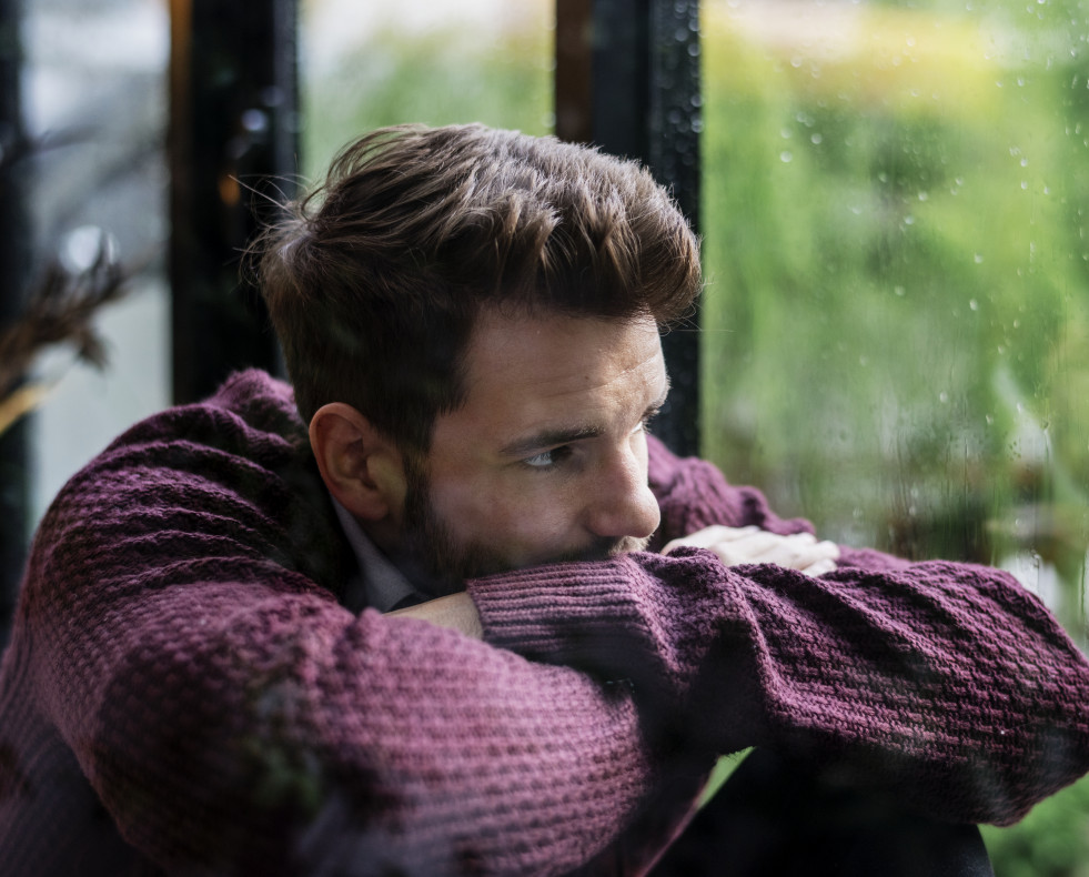 Thoughtful man looking out window