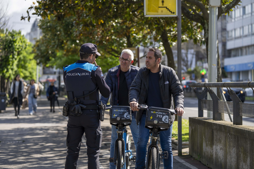 Un policía local aborda a dos ciclistas en los jardines de Méndez Núñez, ayer  carlota blanco
