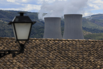GRAFCVA7446. COFRENTES (VALENCIA), 12/05/2025.- Vista general de las torres de refigeración de la central nuclear de Cofrentes asomando tras una casa del pueblo en una imagen tomada este lunes 12 de 