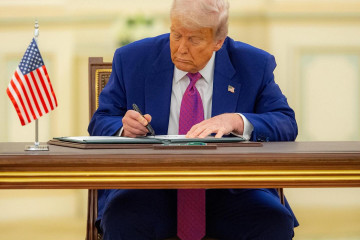 Donald Trump firma un documento