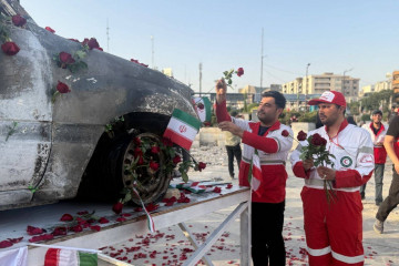 TEHRAN (IRAN (Islamic Republic Of)), 23/06/2025.- A handout picture provided by the Iranian Red Crescent Society (IRSC) shows members of the organisation placing flowers and petals on the Red Crescent