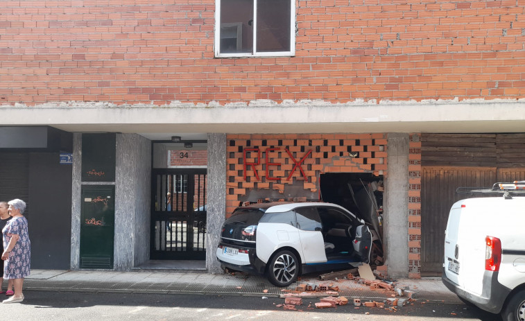 Empotra su coche en el bajo  de un edificio de Guísamo en la maniobra de aparcamiento