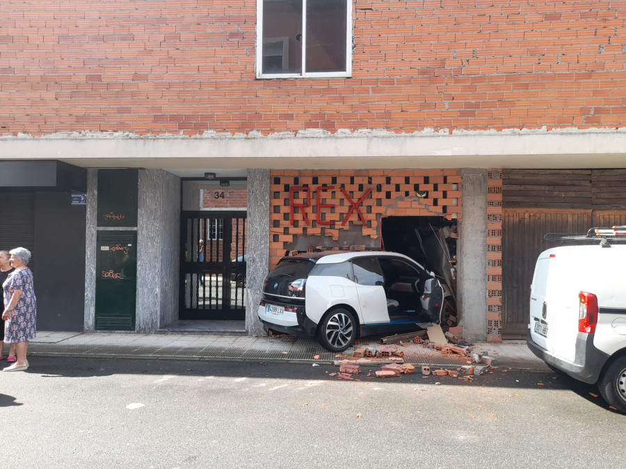 Empotra su coche en el bajo  de un edificio de Guísamo en la maniobra de aparcamiento