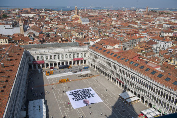 VENICE (Italy), 23/06/2025.- A handout photo made available by Greenpeace press office shows activists of the environmental group Greenpeace unfolding a giant banner with the image of US businessman a