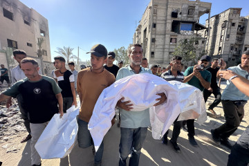Un grupo de hombres participa en el funeral de una de las víctimas del genocidio