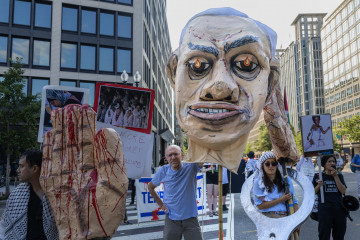 Un grupo de manifestantes protestan por el genocidio en Gaza con imágenes de Netanyahu