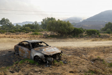 TARIFA (CÁDIZ), 06/08/2025.- Un coche calcinado por el fuego en Tarifa, Medios del Servicio de Extinción de Incendios Forestales de Andalucía (Infoca) prosiguen este miércoles la lucha contra el i
