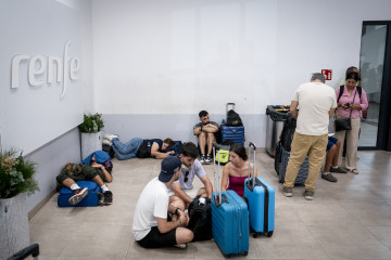 Varias personas esperan con maletas en la estación de Chamartín