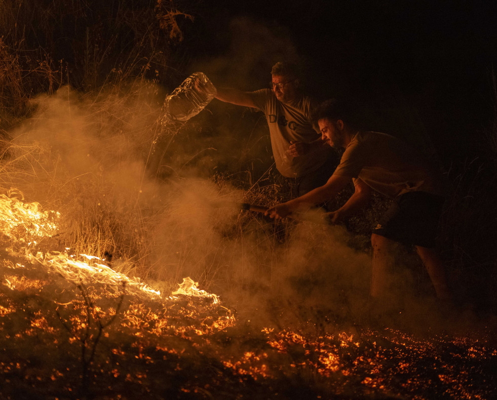 A RÚA (OURENSE), 17/08/2025.- Vecinos de la localidad trabajan la madrugada de este domingo en labores de extinción del incendio forestal de A Rúa (Ourense). Los incendios han calcinado más 50.000