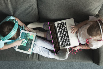 Vista superior de dos ninos con portatil y tablet