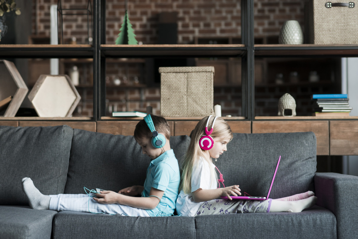 Dos ninos en sofa con portatil